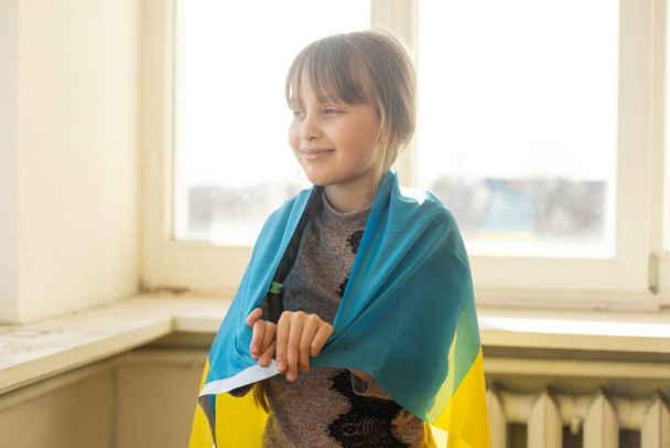 Ukrayna 'nın sarı-mavi bayrağıyla küçük bir kız, savaşı durdurun, protesto ve vatanseverlik, barış umudu. - Fotoğraf, Görsel