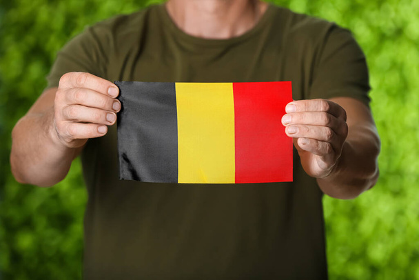 Mann mit belgischer Flagge auf farbigem Hintergrund, Nahaufnahme - Foto, Bild