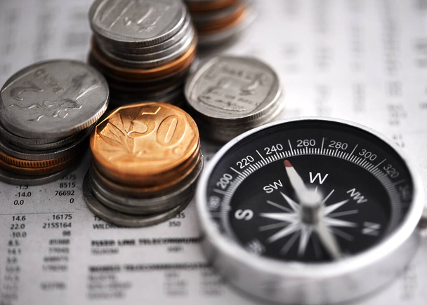 Leading the way to financial success. Studio shot of coins and a compass on some documents. - Photo, Image