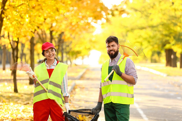 Arbeiter sammeln Herbstlaub im Freien - Foto, Bild