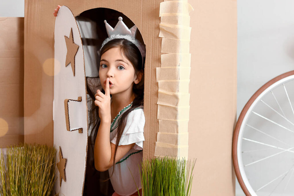Lustiges kleines Mädchen spielt zu Hause mit Papphaus - Foto, Bild