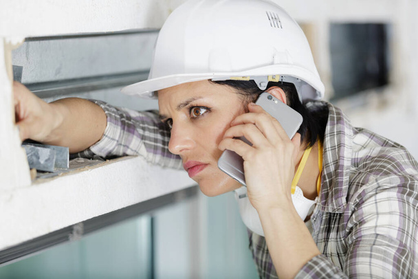 female building contractor using a smartphone - Fotoğraf, Görsel