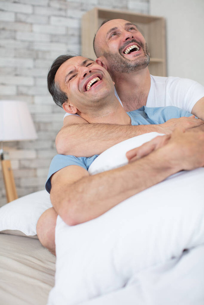 happy gay couple embraced joking and having fun in bed - Фото, зображення