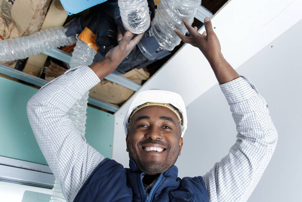 happy man fixes the ceiling from water leak - Foto, immagini
