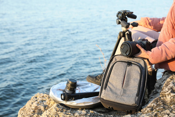 Photographer with professional equipment on rocky river coast, closeup - Zdjęcie, obraz