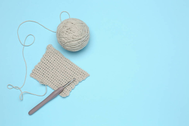 Clew of thread, knitting and crochet hook on light blue background, flat lay. Space for text - Foto, Imagem
