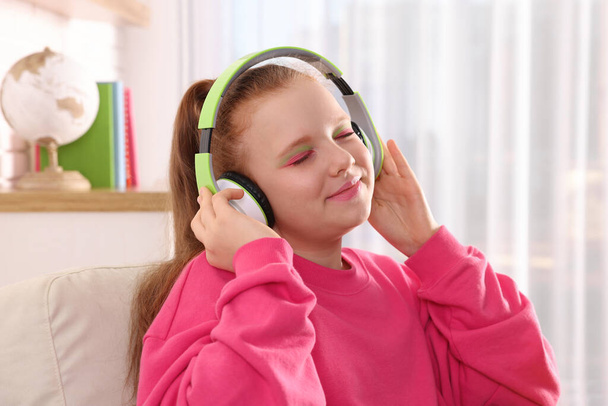 Cute indie girl in headphones listening music at home - Фото, изображение