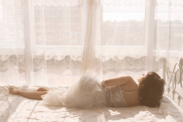 beautiful young woman in white lingerie on the bed - 写真・画像