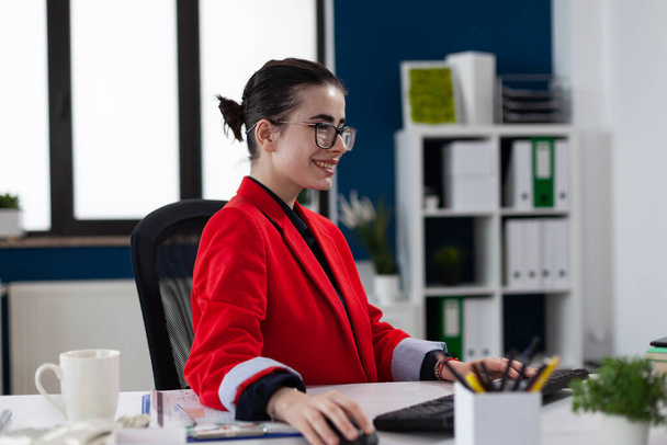 Proprietario startup sorridente con occhiali che lavora alla scrivania in ufficio. - Foto, immagini