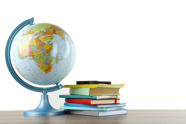 Globe, school supplies and magnifying glass on wooden table against white background. Geography lesson - 写真・画像