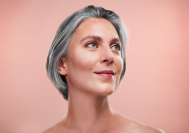 The best foundation you can wear is glowing, healthy skin. Studio shot of a beautiful mature woman posing against a peach background. - Foto, afbeelding