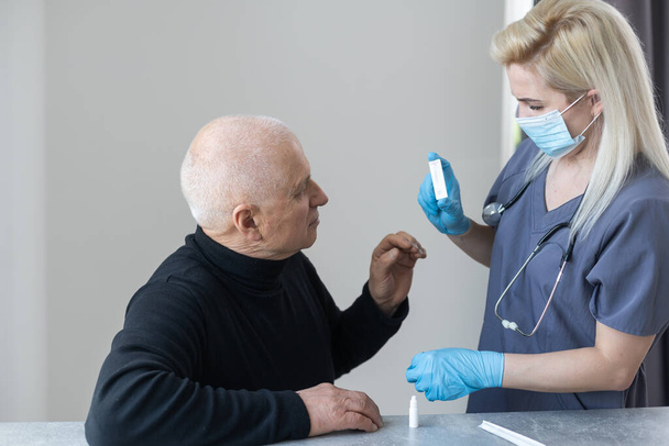 Médico que utiliza la prueba de hisopo nasal coronavirus COVID-19 con ancianos mayores en el hospital. Examen médico para COVID-19 en el hospital. - Foto, Imagen