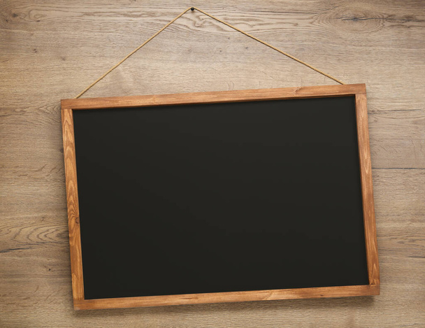 Clean black chalkboard hanging on wooden wall - Photo, Image