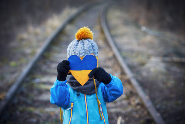 Εικόνα ενός παιδιού με πολλή αγάπη και γαλήνιο μήνυμα κρατώντας την καρδιά - Φωτογραφία, εικόνα
