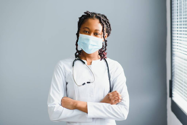 medicine, profession and healthcare concept - close up of african female doctor or scientist in protective facial mask. - Foto, imagen