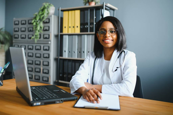African female doctor make online telemedicine video call consult patient. Afro american black woman therapist talking to camera in remote videoconference chat. Webcam view, face headshot - 写真・画像