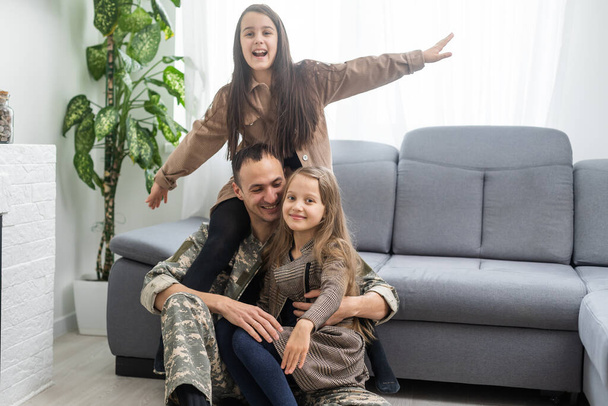 Onnellinen sotilaallinen isä pitelee tytärtä. perhe, siteet ja isänmaallisuus. - Valokuva, kuva