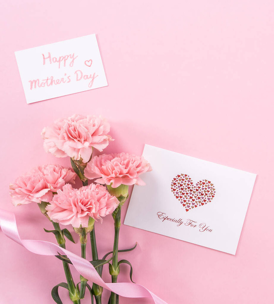 Beautiful fresh blooming baby pink color tender carnations isolated on bright pink background, mothers day thanks design concept,top view,flat lay,copy space,close up,mock up - Foto, Bild