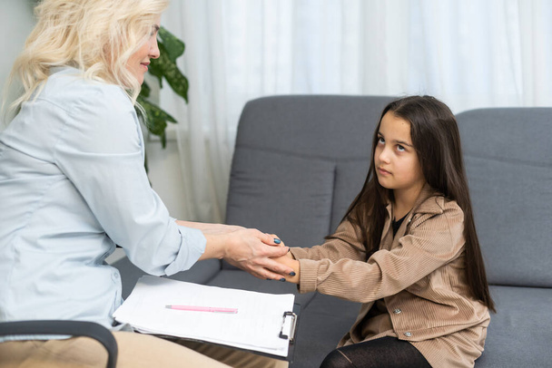 Communication session of school psychologist and girl 9, 10 years. Child tells psychotherapist his experiences, mental health of children. - Zdjęcie, obraz