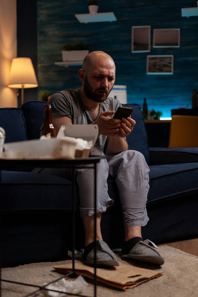 Verwirrter ängstlicher Mann blickt auf Smartphone-Bildschirm - Foto, Bild