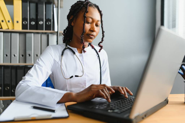 healthcare, medical and technology concept - african female doctor with laptop. - Φωτογραφία, εικόνα