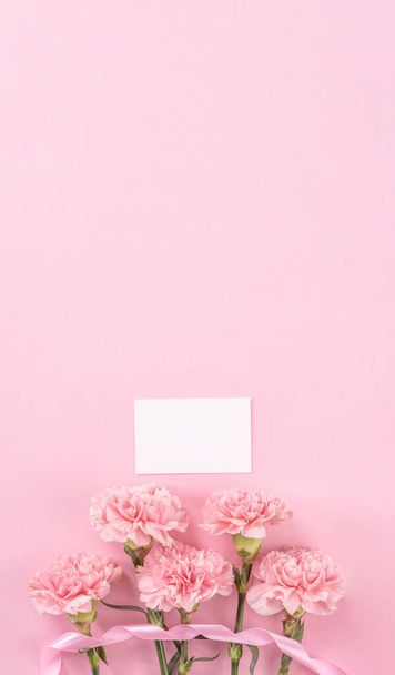 Top view, flay lay, copy space, close up, mock up, mothers day thanks design concept. Beautiful fresh blooming baby pink color carnations isolated on bright pink background - Φωτογραφία, εικόνα
