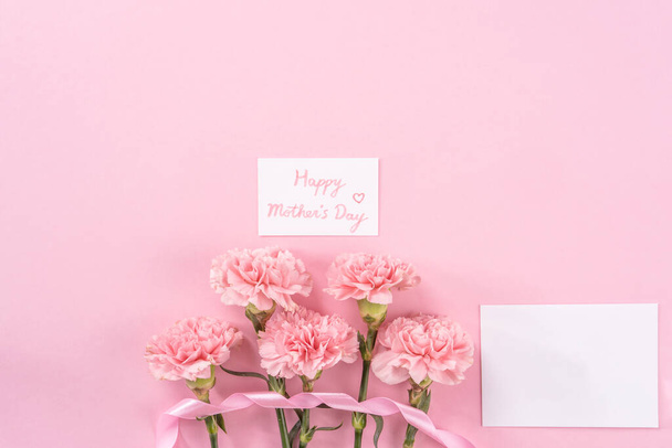 Top view, flay lay, copy space, close up, mock up, mothers day thanks design concept. Beautiful fresh blooming baby pink color carnations isolated on bright pink background - Foto, Bild