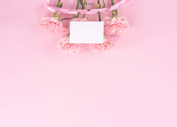 Top view, flay lay, copy space, close up, mock up, mothers day thanks design concept. Beautiful fresh blooming baby pink color carnations isolated on bright pink background - 写真・画像