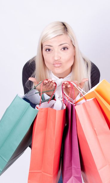Retrato de una mujer rubia con bolsas de compras en un estudio
 - Foto, imagen