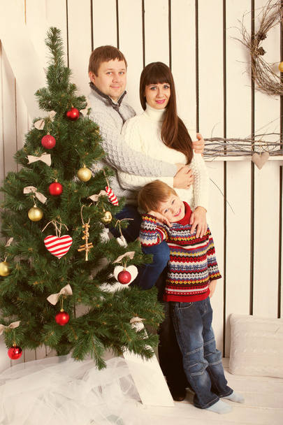  parents and kid near Christmas tree. - Фото, изображение