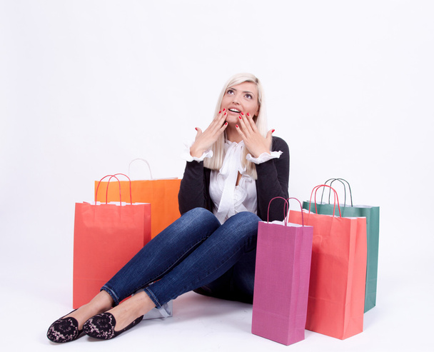Retrato de una mujer rubia con bolsas de compras en un estudio
 - Foto, Imagen