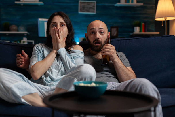 POV of shocked girlfriend and boyfriend watching horror movie - Photo, Image