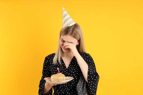 Fogalom a születésnap boldogtalan fiatal nő sárga alapon - Fotó, kép