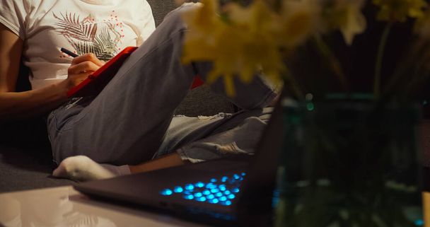 Jovem mulher escrevendo notas com laptop casa. - Foto, Imagem