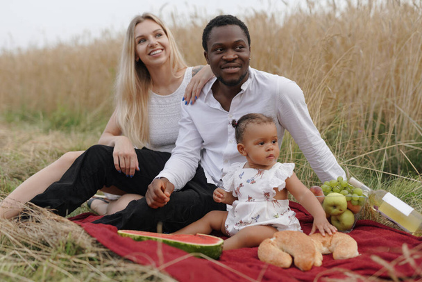 Porträt liebevoller Eltern und ihrer Tochter beim Picknick - Foto, Bild