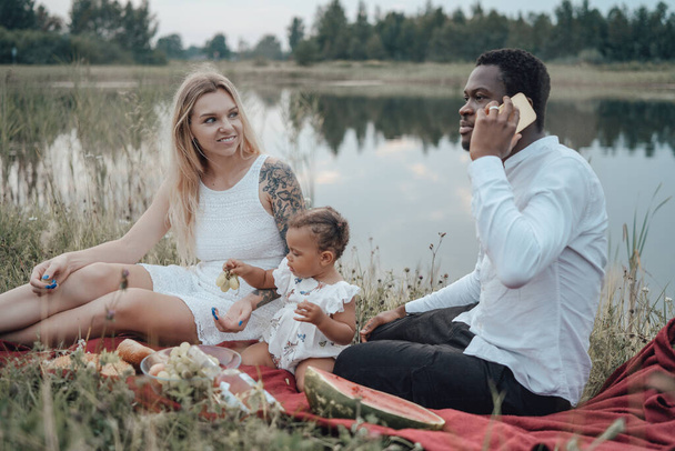 Happy family of multiethnic couple and their little girl - Photo, Image