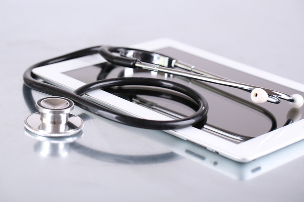 Medical equipment concept. Stethoscope and tablet on light background - Photo, Image