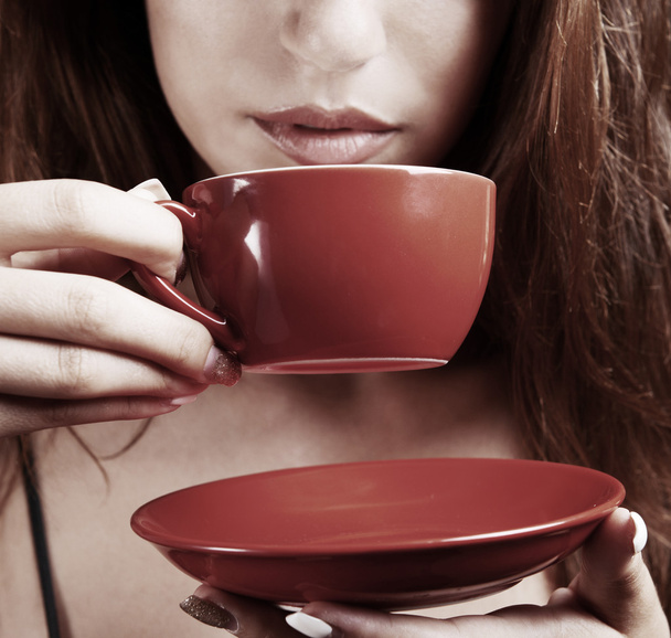 Beautiful young girl with cup of coffee on brown background - Фото, зображення