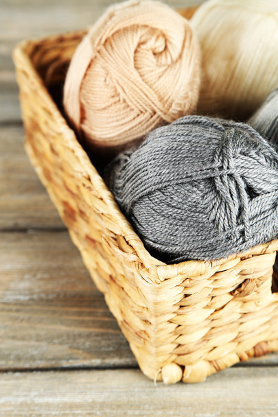 Knitting yarn in basket, on wooden background - Photo, Image