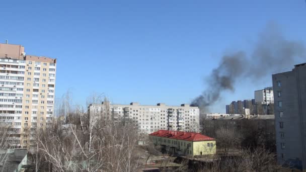 Hay humo negro de un cohete o explosión de una bomba en una ciudad durante una guerra - Imágenes, Vídeo
