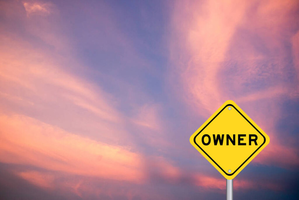 Κίτρινη πινακίδα μεταφοράς με λέξη ιδιοκτήτη στο βιολετί φόντο του ουρανού χρώμα - Φωτογραφία, εικόνα