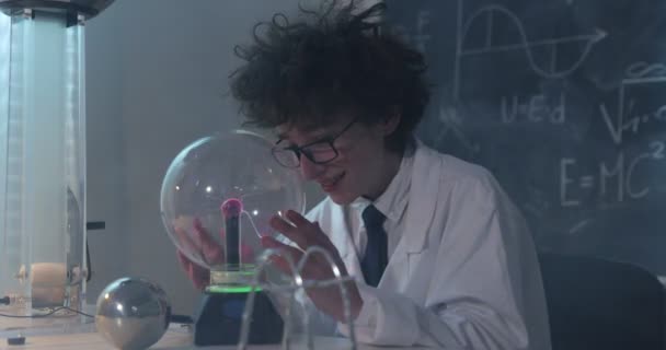 Educazione, scienza e concetto di bambini: il ragazzo indossa occhiali per il laboratorio di fisica che fa test elettrici. Bambino che studia scariche elettriche in un laboratorio. - Filmati, video