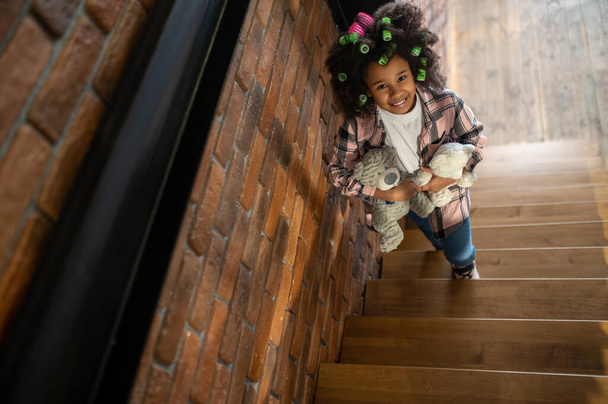 Top view of girl with toys standing on stairs - Фото, изображение