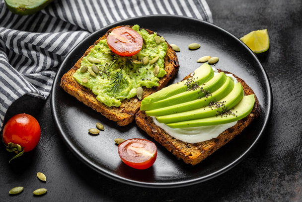 Healthy avocado toasts for breakfast or lunch with cherry tomato, rye bread and cream cheese, pumpkin seeds. Breakfast with vegetarian food, diet concept. - Foto, immagini