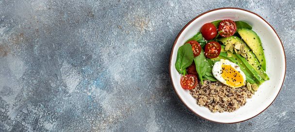 Quinoa buddha bowl with avocado, egg, tomatoes, spinach and sunflower seeds on a light background. Homemade food. Healthy, clean eating. Vegan or gluten free diet, Long banner format. top view. - Photo, Image