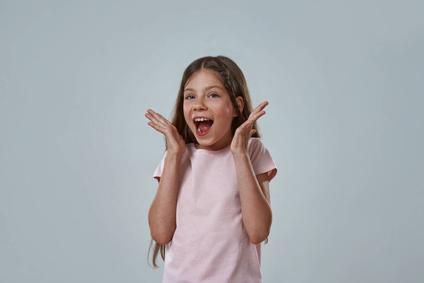 Excited little girl with open mouth and arms - Photo, Image