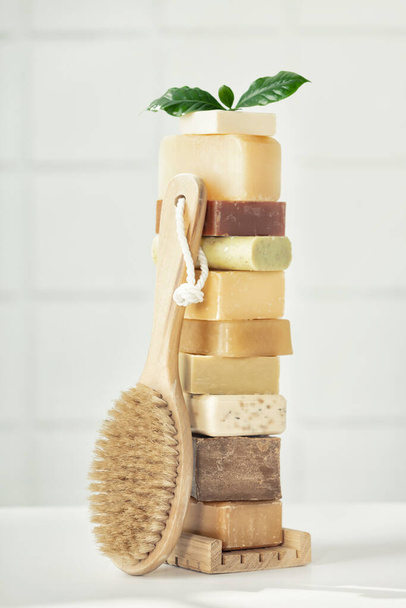 Stack of assorted natural soap bars on white bathroom countertop - Foto, Imagen