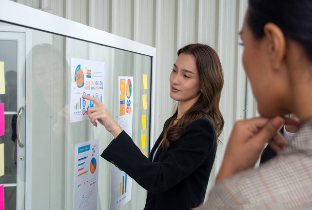 Business people meeting at office and use post it notes to share idea. Analyzing information on chart.  Brainstorming concept. Sticky note on glass wall. - Foto, immagini