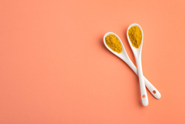 yellow curry spice in two ceramic spoons - healthy food - 写真・画像