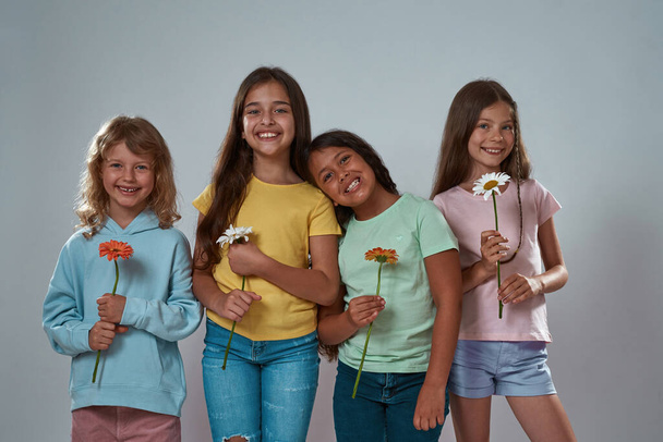 Little girls with gerbera and chamomile flowers - Photo, Image